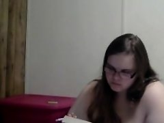 Nerdy girl smokes naked while reading in bed